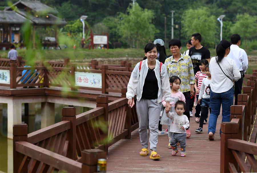 4月19日，在广西南宁市青秀区南阳镇施厚村古岳坡，游客在观看米粉制作。