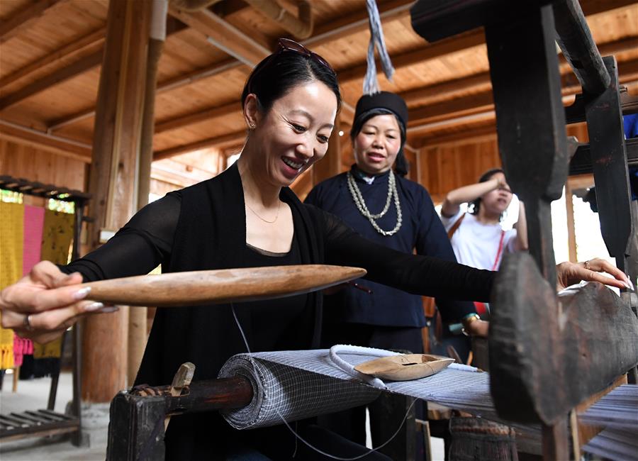 4月19日，在广西南宁市青秀区南阳镇施厚村古岳坡，游客在观看米粉制作。