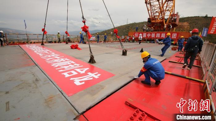 7月1日，中(中国)老(老挝)铁路中国段玉(玉溪)磨(磨憨)铁路元江双线特大桥最后一块桥面板精准落入预定位置。　陈于飞 摄